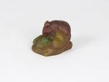 a small figurine of a bear sitting on a rock
