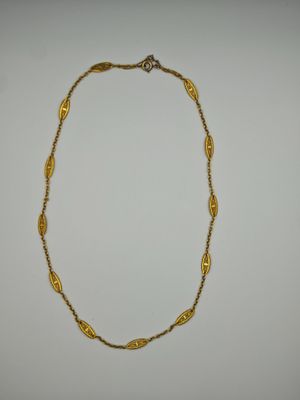 a gold necklace on a white background