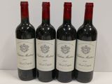three bottles of red wine are lined up on a table