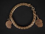 un gros plan d'un bracelet en or orné de deux breloques