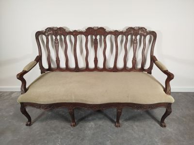 Canapé trois places en bois mouluré et sculpté à dossier ajo…