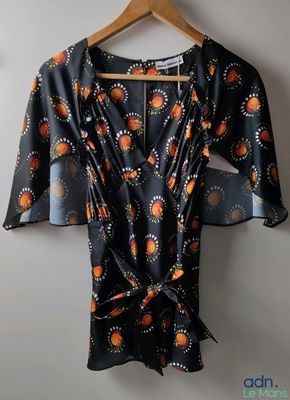 une robe noire et orange suspendue à un cintre