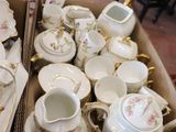 many cups and saucers in a box on the floor