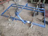 une photo d'une remorque bleue munie de roues, sur un terrain en terre battue