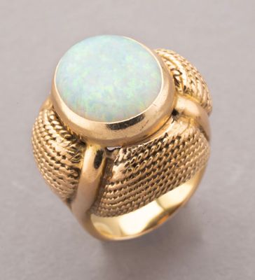 a close up of a gold ring with a white oplite in it