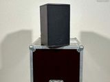 a black speaker sitting on top of a wooden box