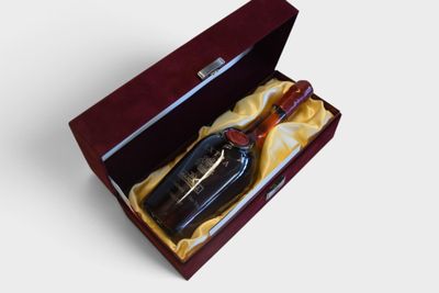 a bottle of liquor in a box on a white surface