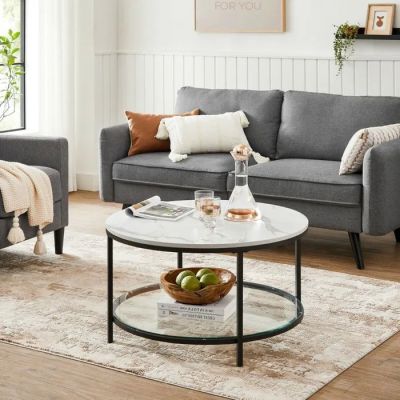 un salon avec un canapé gris et une table basse blanche