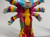 brightly colored figurine of a cat on a skateboard on a white surface