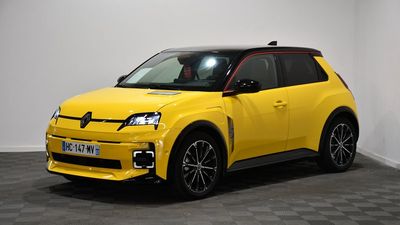the yellow car is parked in a room with a checkered floor