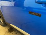 a close up of a blue car with a sticker on it