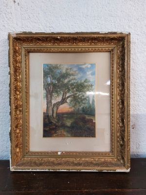 an old picture of a tree in a gold frame on a table