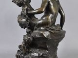 a bronze statue of a woman sitting on top of a rock