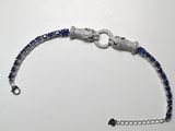 un bracelet en perles bleues et blanches posé sur une table blanche