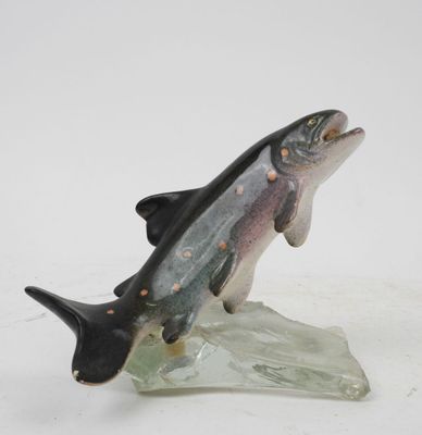 figurine of a fish on a rock on a white surface