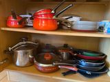 many pots and pans on a shelf in the kitchen