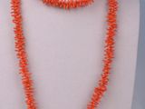 a necklace made of orange coral beads on a mannequin