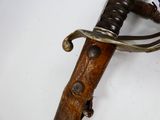 a close up of a sword on a white surface