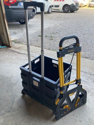 un chariot noir et jaune muni d'une poignée, posé sur le trottoir
