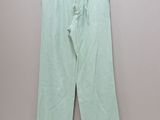 a pair of green pants hanging on a hanger in a room