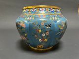 a blue vase with a gold lid sitting on a table