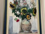 a painting of flowers in a vase hanging on a wall