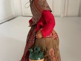 figurine of a woman sitting on a barrel holding a pot