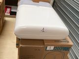 un réfrigérateur blanc posé sur des cartons dans une pièce
