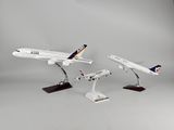Deux maquettes d'avions sont posées sur un socle, sur une surface grise.
