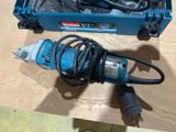 a small electric drill in a blue box on a table
