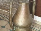 a large metal pot sitting on the floor in front of a door