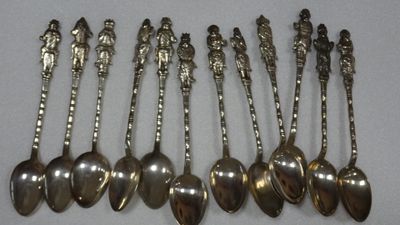 six silver spoons are lined up in a row on a table