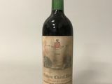 une vieille bouteille de vin posée sur une table blanche