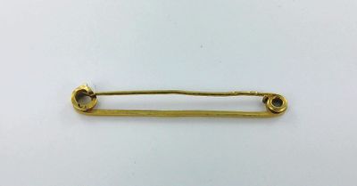 une épingle de sûreté dorée sur fond blanc