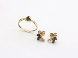 a close up of a gold ring and a pair of earrings on a white surface