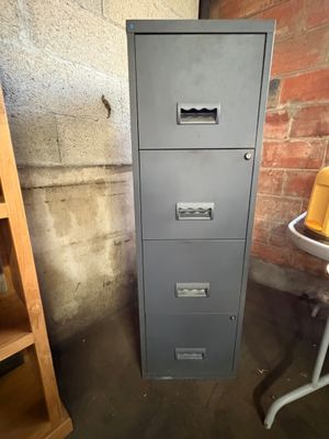a filing cabinet in the corner of a room next to a table