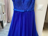 a blue dress hanging on a hanger in a room