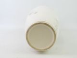 a close up of a white cup on a white surface