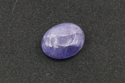 a purple stone sitting on top of a black surface