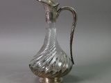a silver and glass pitcher sitting on a table