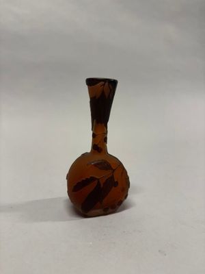 un petit vase posé sur une surface blanche