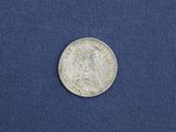 a close up of a silver coin on a blue cloth