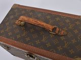 a brown and tan suitcase sitting on top of a white table