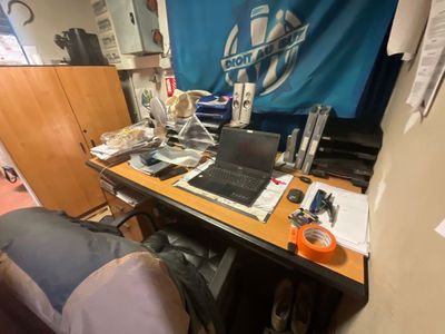 un bureau sur lequel se trouve un ordinateur portable, dans un coin de la pièce
