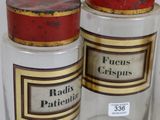 three glass jars with labels on them sitting on a white surface