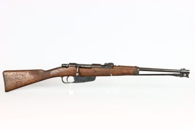 un fusil avec un canon en bois sur une surface blanche