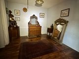 a room with a dresser, mirror, and a rug on the floor