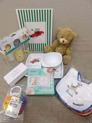 un ours en peluche posé à côté d'une boîte contenant des articles pour bébé