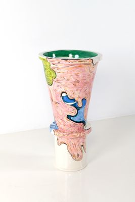 un vase avec un tableau posé sur une table