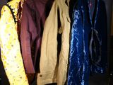 quatre vestes suspendues à un porte-manteau dans une pièce
